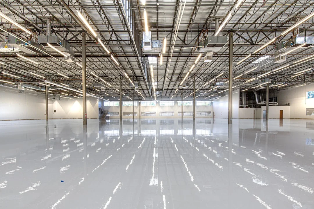 From above anonymous housekeeper in yellow rubber gloves spraying cleaner to chrome water faucet in bathroom